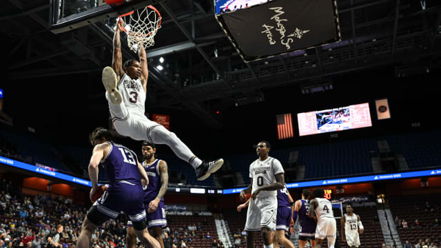 Nov 19, 2023; Uncasville, CT, USA; Mississippi State Bulldogs guard Shakeel Moore (3) hangs on the rim after Dunkin g the ball over Northwestern Wildcats guard Brooks Barnhizer (13) while Mississippi State Bulldogs forward D.J. Jeffries (0) looks on during the second half at Mohegan Sun Arena. Mandatory Credit: Mark Smith-USA TODAY Sports